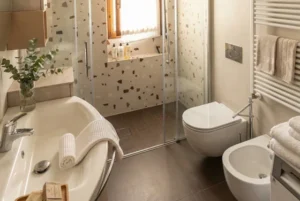 Don Milani: bagno con doccia in cristallo, lavabo, sanitari e scaldasalviette